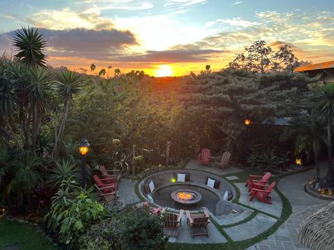 Sunset overlooking a garden with a fire pit.
