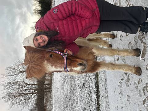 Woman with a horse posing in a snowy field.