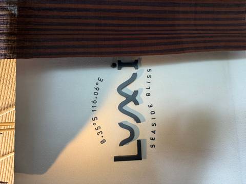 Close-up of a wall with the text 'Seaside Bliss' and coordinates.