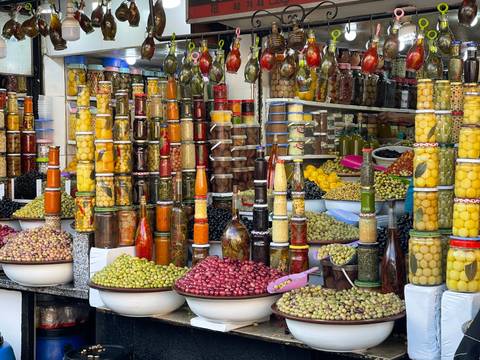 Colorful display of pickled vegetables and spices at a market.