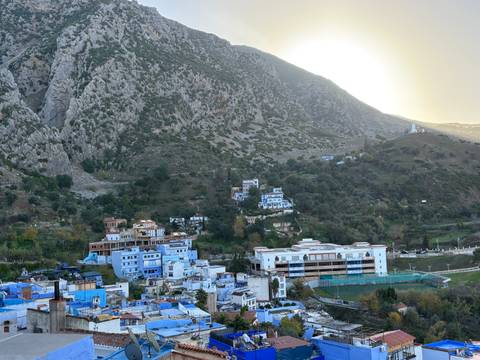 View of Chefchaouen's blue buildings against the mountains.