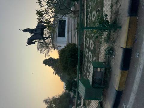       Equestrian statue in a park during sunset.
  