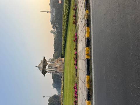 Stone pavilion in a garden surrounded by flowers.