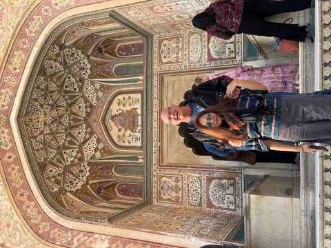       Couple standing in front of a decorated archway.
  
