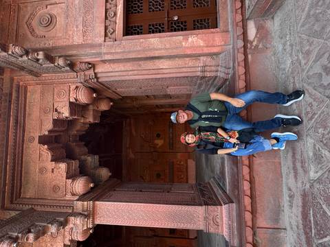 Couple sitting at the entrance of a red sandstone building.