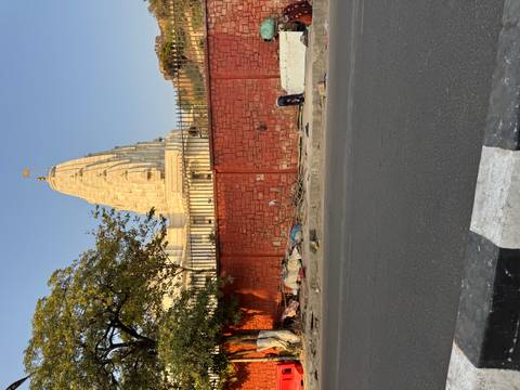       Temple viewed from across the street, high red wall in front.
  