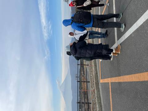 Group of people in winter clothing with Mount Fuji in the background.
