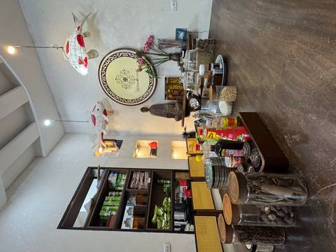 Interior of a shop with various food items and spices displayed on a wooden counter.