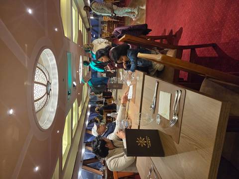 Dining scene inside a restaurant with multiple people interacting.