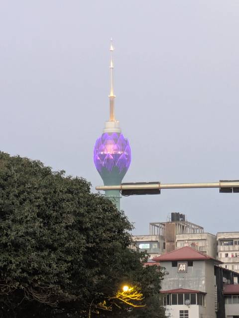 Lotus Tower with purple lighting, viewed from a distance.