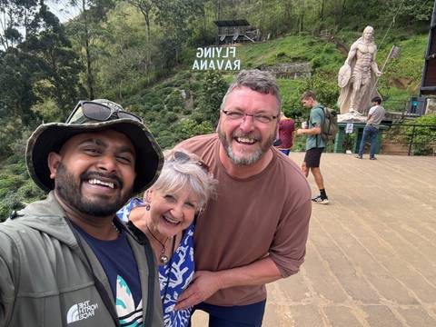 Three people smiling for a selfie outdoors.