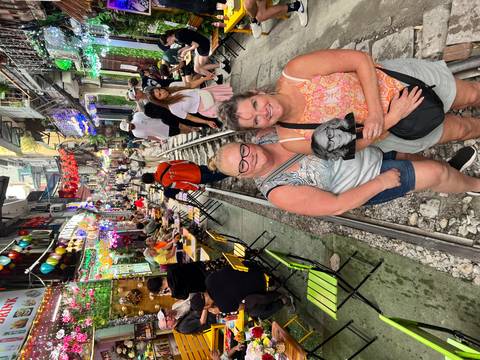 Crowded lively street with vibrant decorations and people enjoying outside cafes.