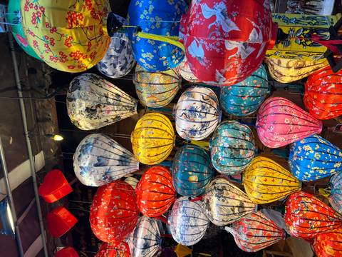 Display of colorful lanterns with various intricate designs hanging closely together.