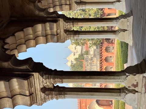       An architectural view through an archway showing domed buildings.
  