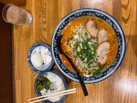 Bowl of ramen with other Japanese dishes on a wooden table.