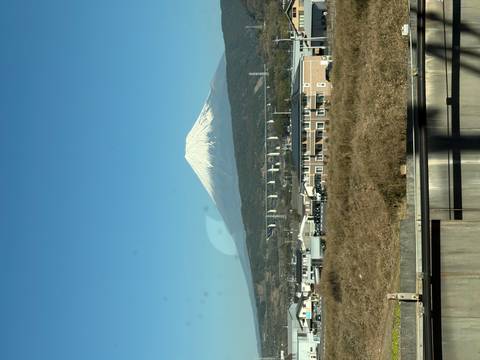 Mount Fuji in the background with a clear sky and a town in the foreground.