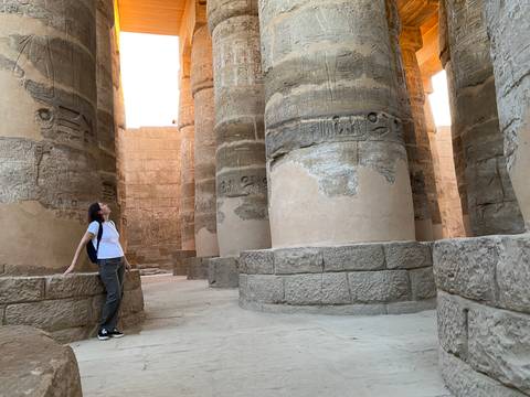 A person admiring the grand columns of Karnak in Luxor.