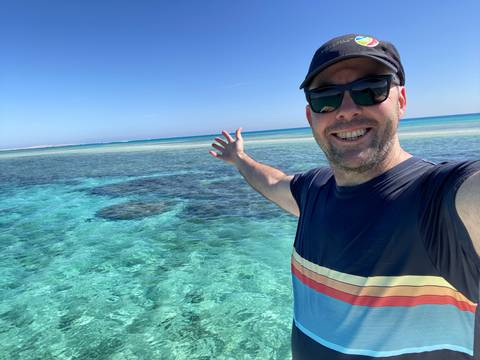 A person enjoying the clear blue waters at a beach.