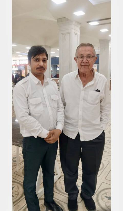 Two men in white shirts posing indoors