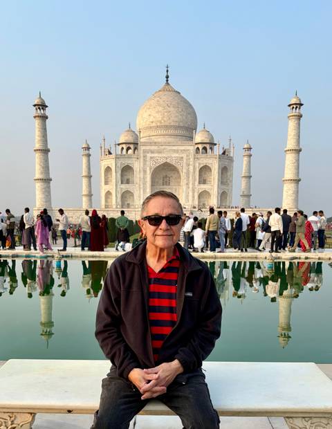 Man posing in front of the Taj Mahal reflection pool
