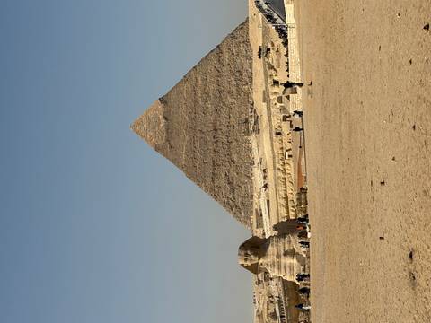       Pyramid with Sphinx in foreground under clear skies
  