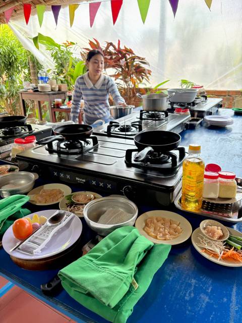 Cooking class setting with various ingredients and cooking equipment.