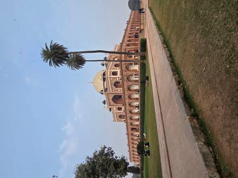 Humayun's Tomb amidst a garden with people sitting on the lawn.