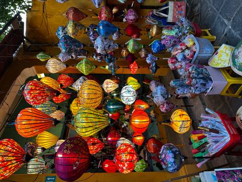      Colorful Vietnamese lanterns hanging in a market scene.
  