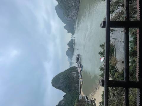       View of Halong Bay with limestone karsts and moody sky.
  