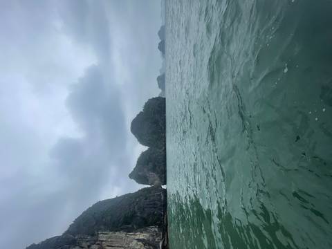       Limestone islands in Halong Bay under a cloudy sky.
  
