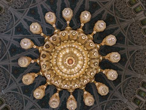       Intricate chandelier with patterns on the ceiling, view from below.
  