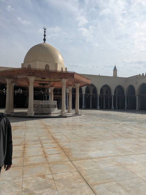       Historic mosque courtyard with a single person in view.
  