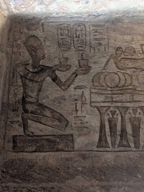       Close-up of an ancient stone wall with Egyptian carvings.
  