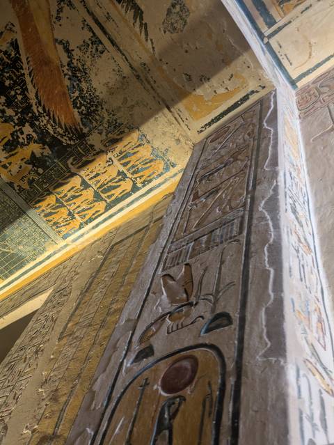       Ancient wall with Egyptian hieroglyphs and colorful paintings.
  