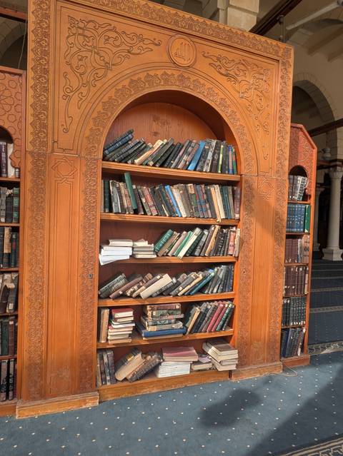       Bookshelf filled with a variety of books in a wooden cabinet.
  