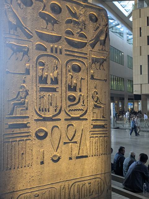 Interior of a museum with Egyptian hieroglyphs on display.