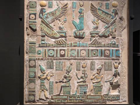       Vibrant stone carving with Egyptian figures in a museum.
  