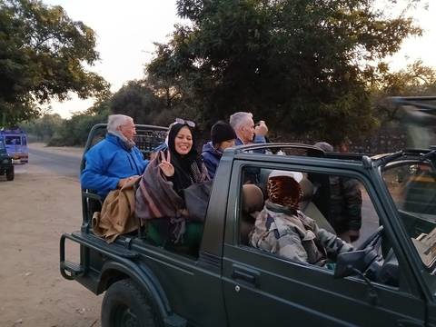 Group of people on a safari jeep drive in a natural setting.