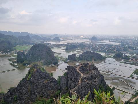 View of a valley with rice fields and mountains in the distance.