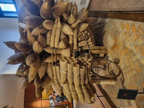 Bicycle loaded with bamboo baskets in a rustic setting.