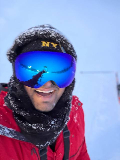 Close-up of a person wearing ski goggles with a reflection.