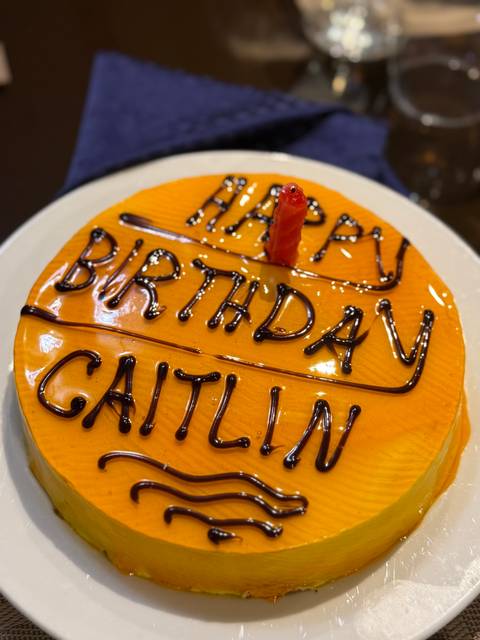 A birthday cake with the message 'Happy Birthday Caitlin'.