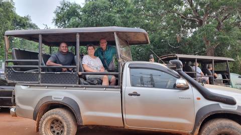       Outdoor safari vehicle with tourists on board.
  
