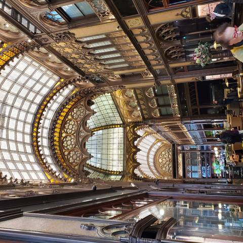       Architecturally intricate indoor atrium with people walking.
  