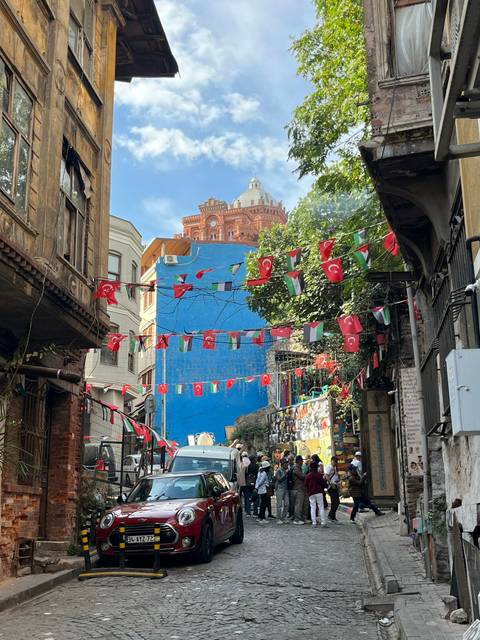 Decorated street with Turkish flags and colorful buildings.
