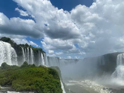 Dramatic view of Iguazu Falls with mist and lush greenery.