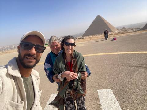 Selfie of a group with pyramids in the background.