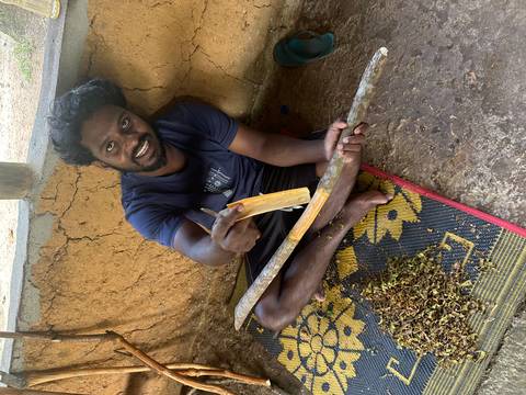       A man seated while interacting with local produce.
  