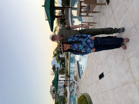 Couple posing by a pool with a distant mountain view.