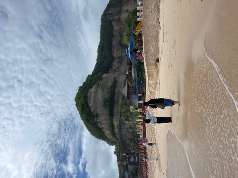 People enjoying a beach surrounded by cliffs.